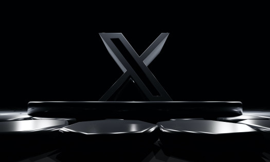 Large, dark grey X logo in front of black background