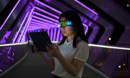 Image of woman using an iPan and VR glasses to explore the Metaverse