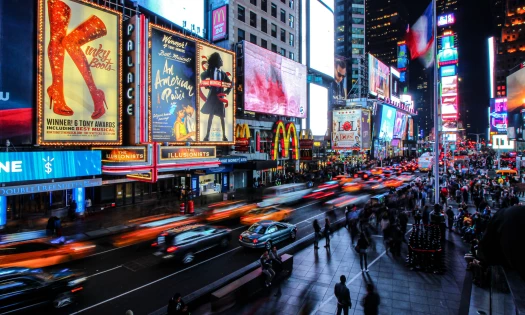 Bustling city at night with a flurry of neon-lit ads on the buildings