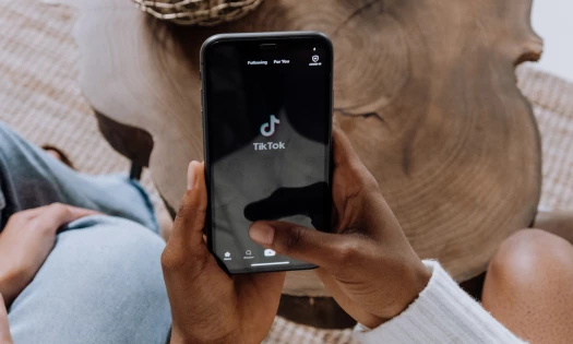 Person holding a smartphone, opening the TikTok application