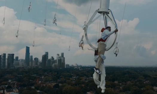People hang in life-size claws over the city