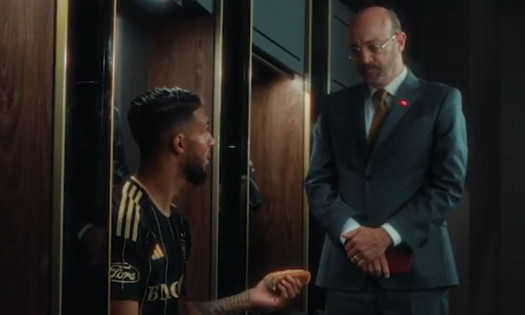 Denis Bouanga with a hot dog talking to a DoorDash accountant.