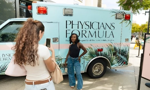Attendees taking photos by the Glambulance during Physicians Formula event