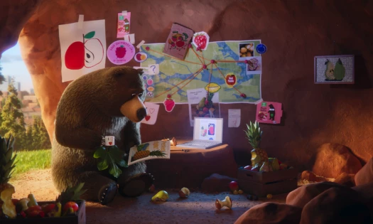 An animated bear reads a book in his cave