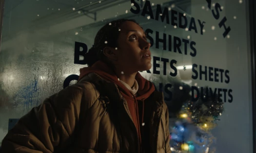 A woman looks on as snow starts falling