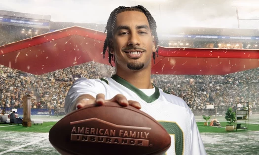 Jordan Love holding a football with the American Family Insurance logo