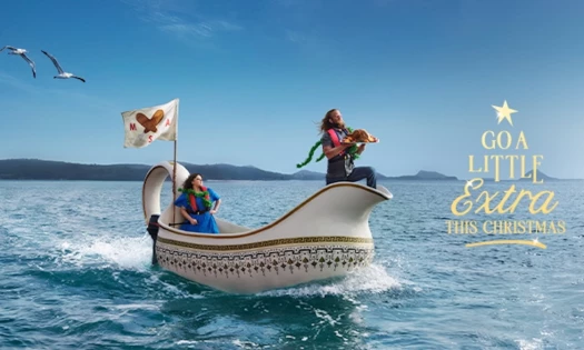 A couple sails at sea in a gravy boat to deliver a turkey for a Christmas party