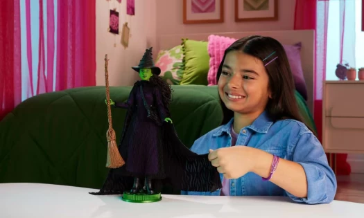 A girl playing with a 'Wicked' doll