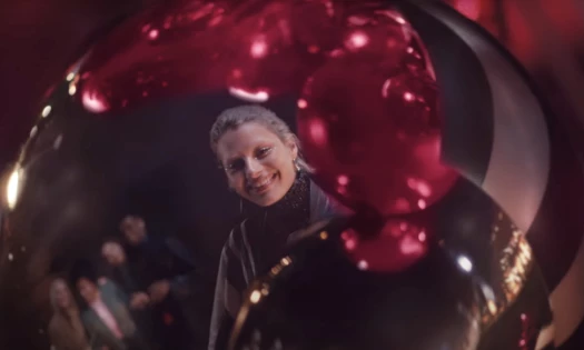 Woman smiling reflected on a Christmas ball in Sephora holiday ad