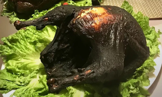 A charred turkey on a bed of lettuce