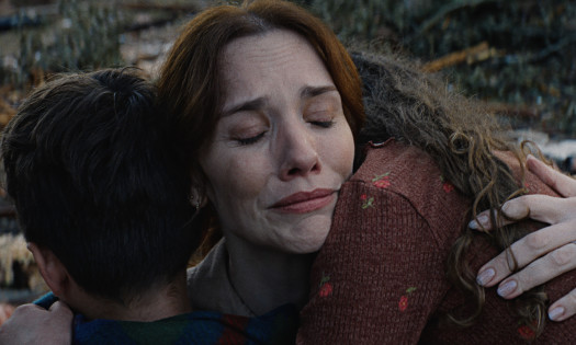 Woman hugging two children after a natural disaster.