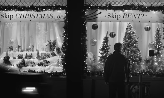 Man standing in front of a shop window decorated for Christmas