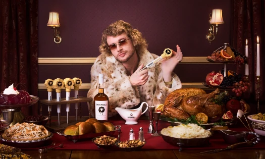 Yung Gravy holds a Skrewball Whiskey baster shot