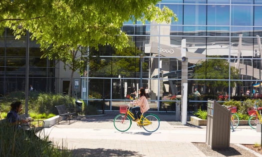 Woman biking within the Google campus
