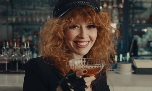 Natasha Lyonne holing up a glass for a toast for Bergdorf Goodman