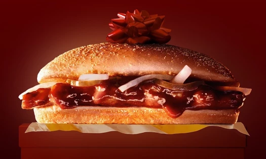 A McRib sandwich with a red ribbon on top