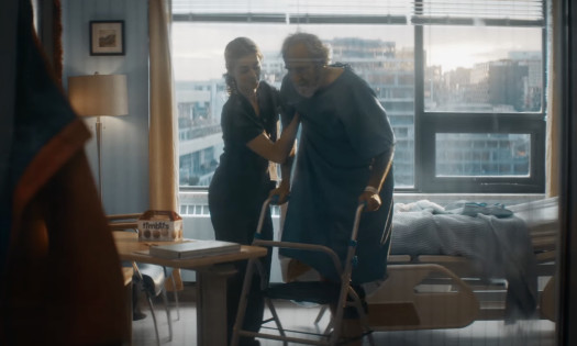 A nurse helping an old man walk