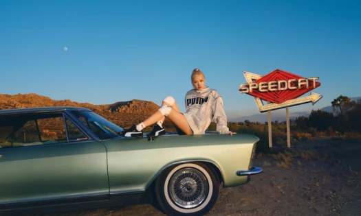 Rosé for Puma's Speedcat sitting on the hood of a green vintage car