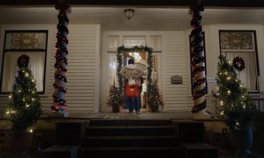 DoorDash driver outside a decorated house for Christmas