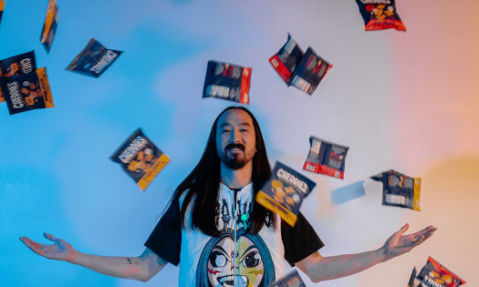 Steve Aoki with Cheddies snacks raining down on him