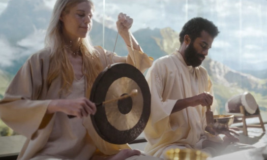 A woman and man sounding gongs and singing bowls