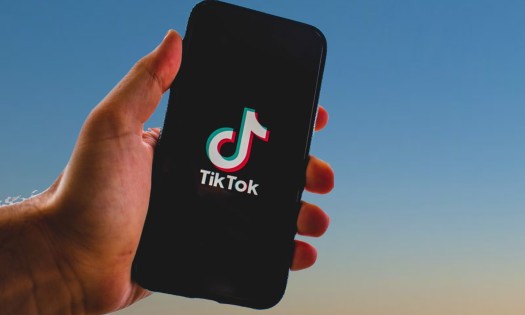 Hand holding a cellphone with TikTok logo