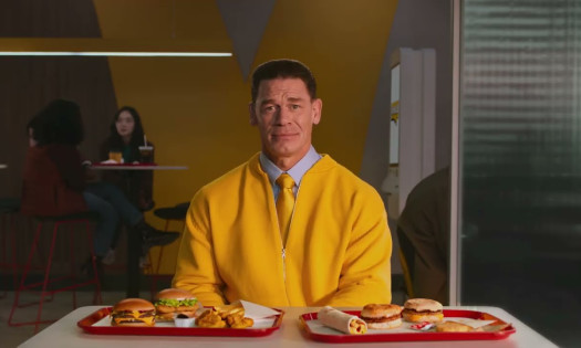 John Cena with a table of McDonald's menu items
