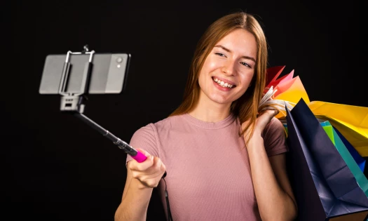 Woman holding up shopping bags for camera