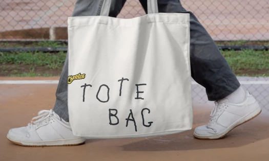 A Cheetos tote bag with 'The Other Hand' font