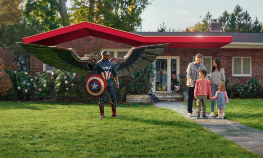 Anthony Mackie's Captain America standing on the front lawn of a house with a family of four