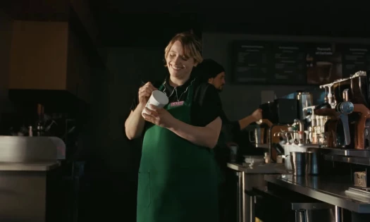 A Starbucks barista writing a note on a customer's cup instead of their name