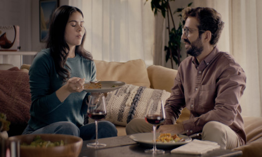 A man and his girlfriend enjoy dinner and wine