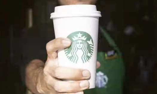 Starbucks barista holding a coffee cup