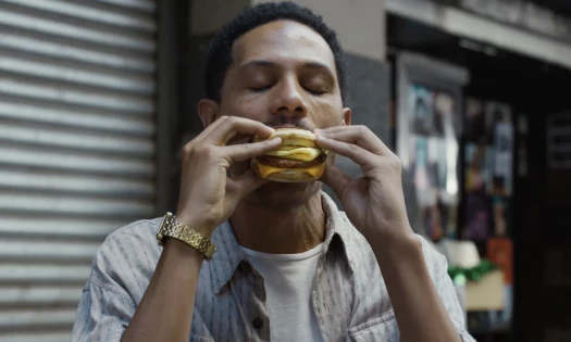 A man biting an Egg McMuffin with eyes closed