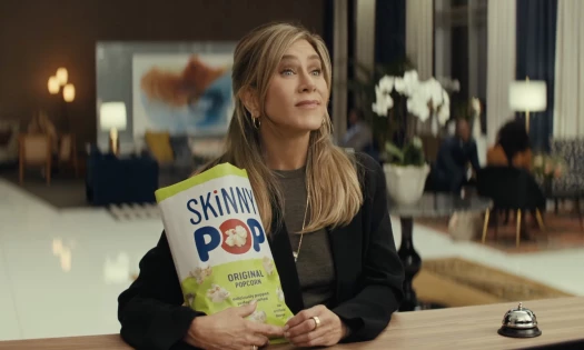Jennifer Aniston holding a bag of SKINNYPOP Popcorn
