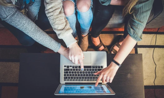 People pointing at a laptop screen