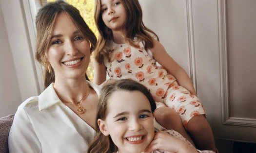 A mom and her two daughters smiling for the camera