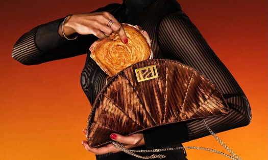 A woman holding a sandwich to put inside Panera Bread's Croissant Clutch
