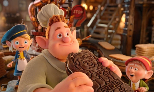 An animated efl bites on a Keebler cookie as other elves look on