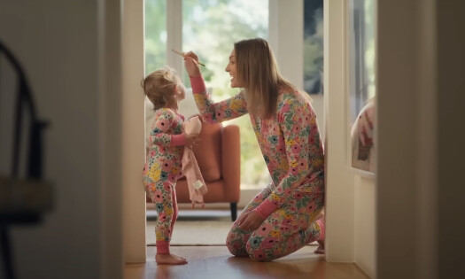 A mom measuring her toddler's height on a wall