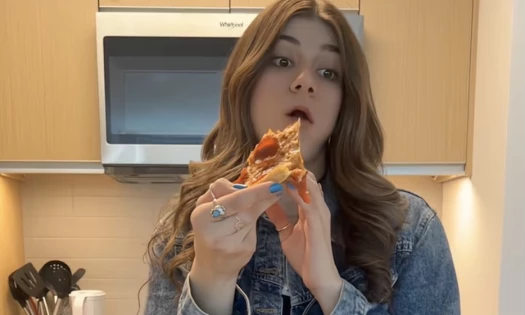 Sydney Jo eating Domino's pizza in the kitchen