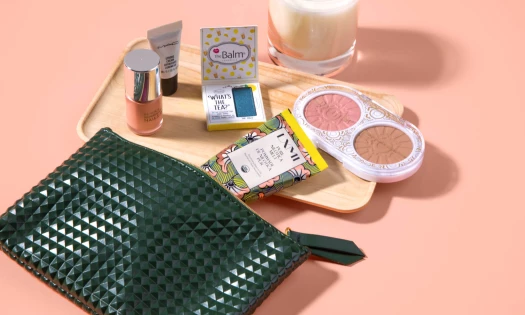 A black pouch with the contents out, showing beauty products commonly found in a makeup kit