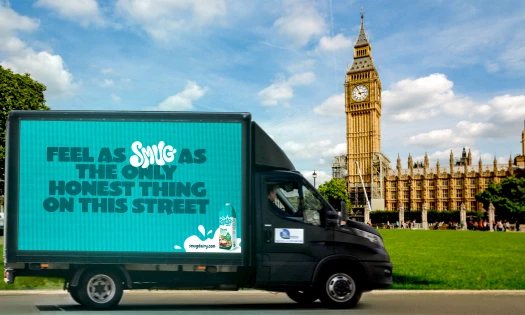 Image showing the Smug truck with a billboard-style ad on the side parked in front of the Big Ben in London.
