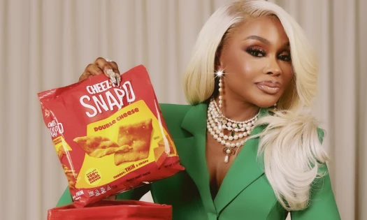 Phaedra Parks in a green outfit holding the new Cheez-It Snap'd Back Bag