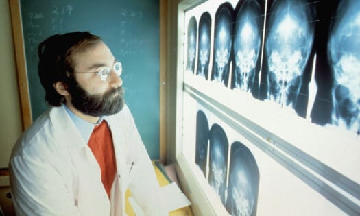 A doctor looking up at a board of x-rays