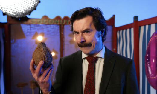 Mike Wozniak wearing a suit and holding a coconut