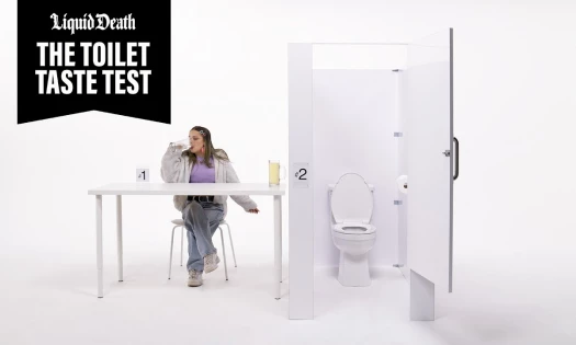 A woman sipping on a mug, as she sits next to a cubicle