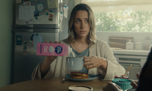 A woman pouring nutpods sweet cream into her drink