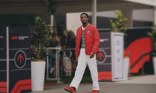 Damson Idris wearing a red racing Tommy Hilfiger jacket
