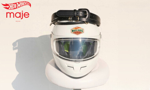 Hot Wheels and Maje logos with a helmet on a white stool and a belt on top of it